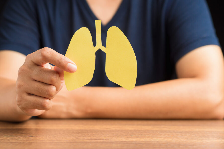 Close-up of hand a man holding lungs symbol while sitting in the hospital