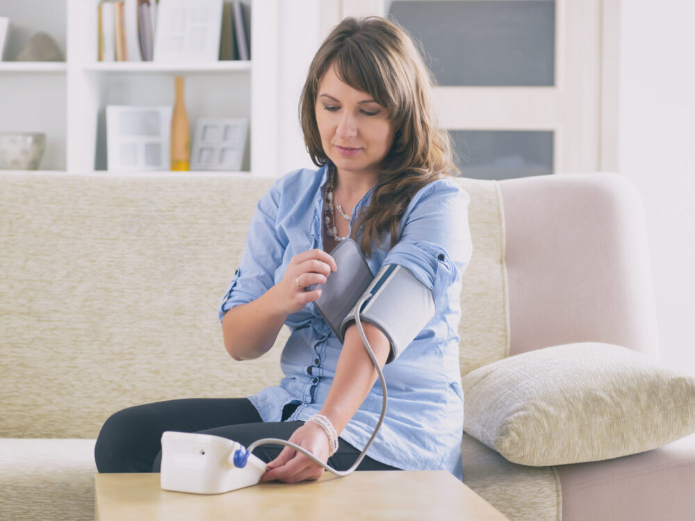 Woman checking blood pressure at home in Essex