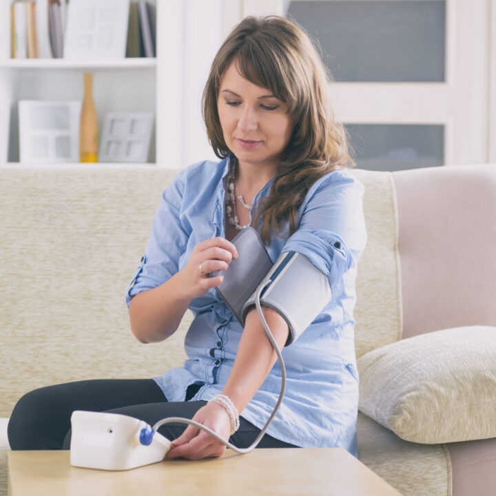 Woman checking blood pressure at home in Essex