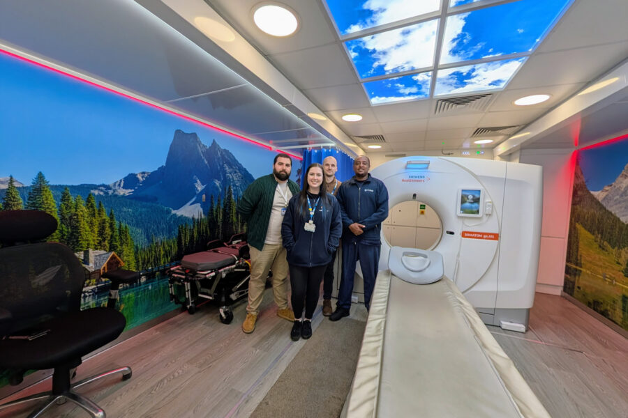 Lung cancer screening team stood next to the scanner