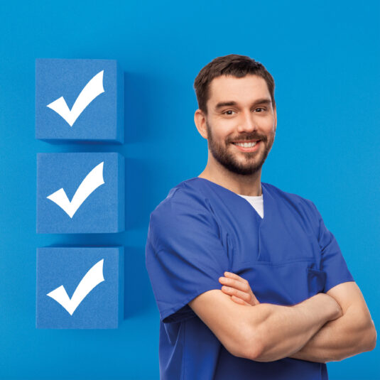 Hospital worker standing next to tick boxes