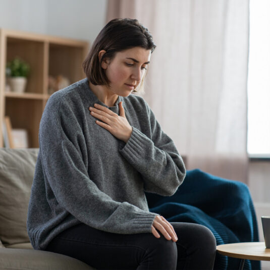 Woman experiencing chest pain or breathing difficulties.