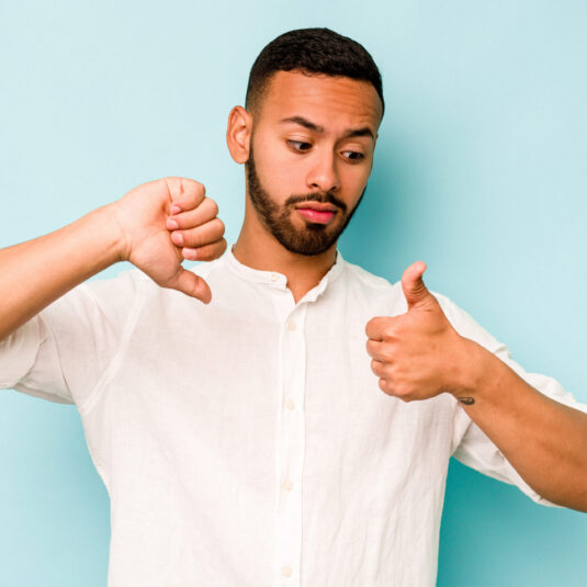 Man showing both thumbs up and thumbs down, representing mixed opinions or feedback.