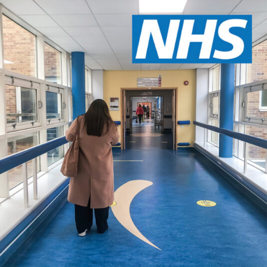 Person walking down a hospital corridor