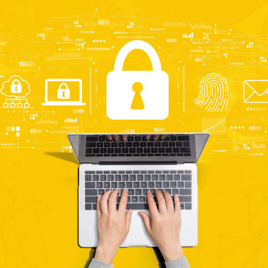 A laptop displaying an NHS online library webpage with the NHS logo and an open book icon. A person using a laptop with digital security icons, including a padlock and fingerprint, representing cybersecurity and data protection.