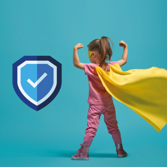 Young child dressed as a superhero standing confidently beside a shield symbol representing protection.