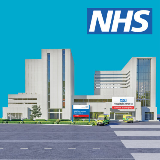 NHS hospital building with emergency entrance and ambulances outside.