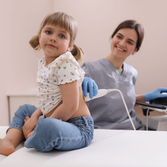 Young child receiving an ultrasound scan from a healthcare professional.