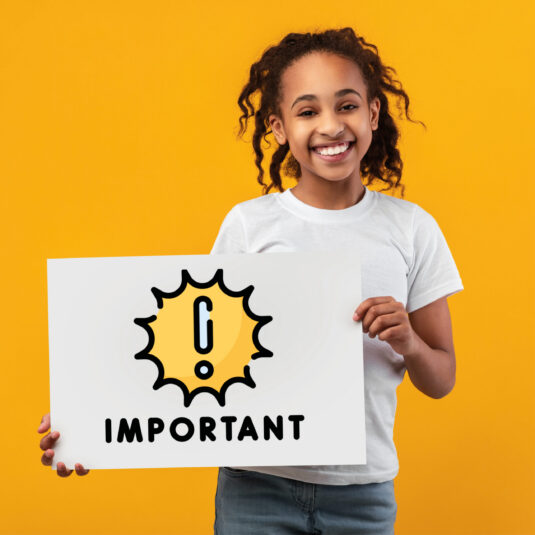 Smiling girl holding a sign labelled “IMPORTANT,” highlighting key information or an important message.