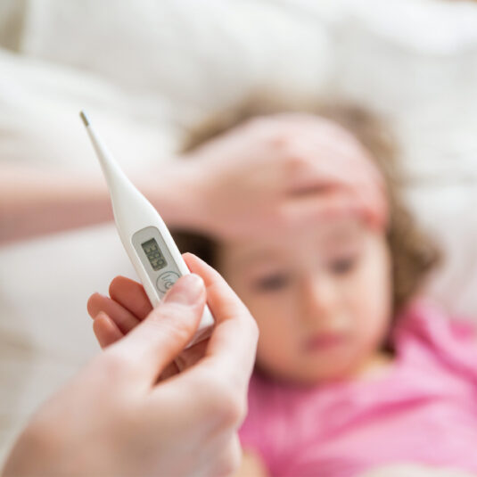 Child having their temperature checked with a