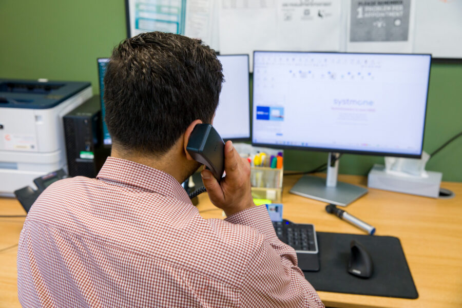 Doctor on the phone whilst looking at a computer